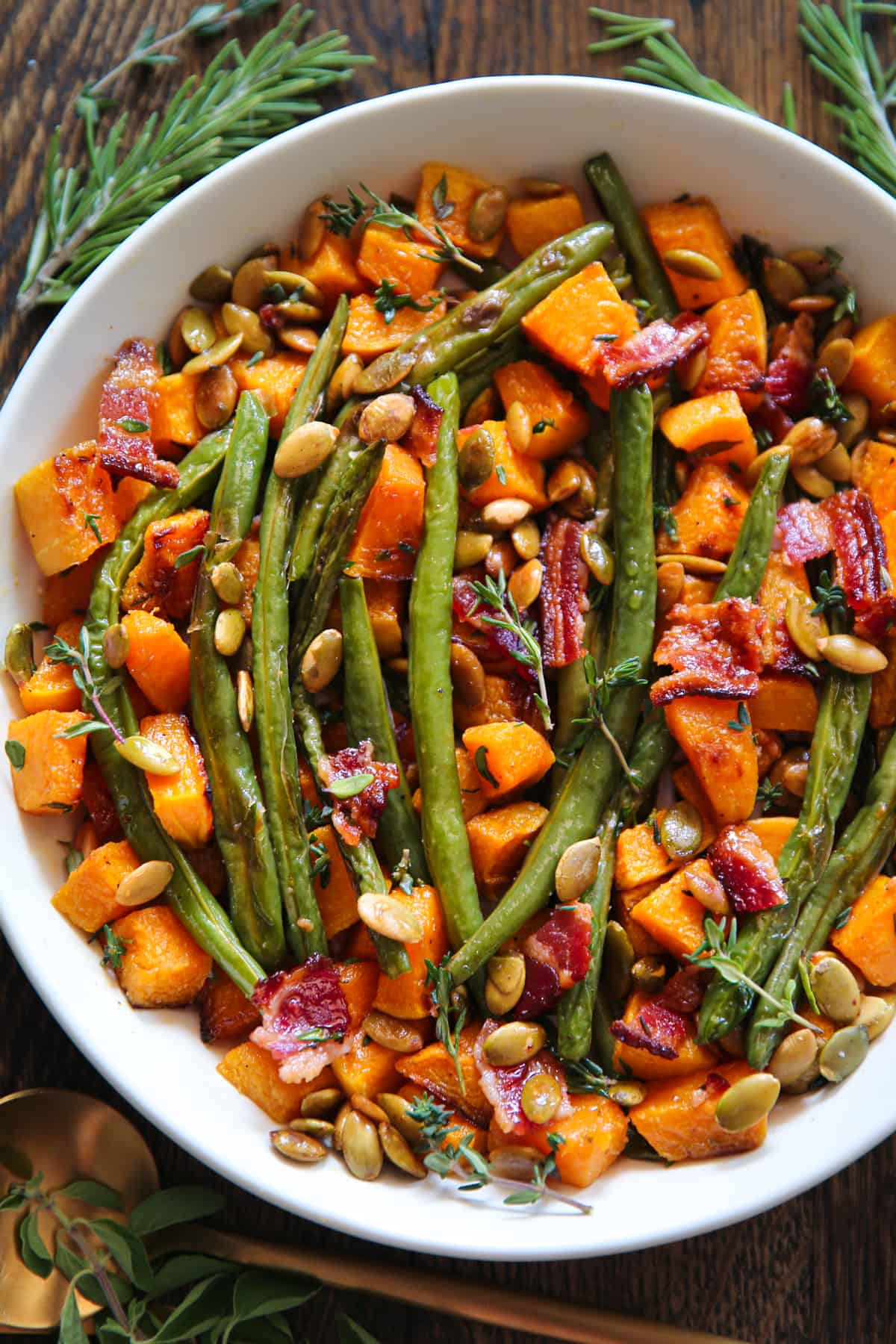 Thanksgiving Roasted Vegetables (Butternut Squash and Green Beans) with Bacon and Pumpkin Seeds in a white bowl.