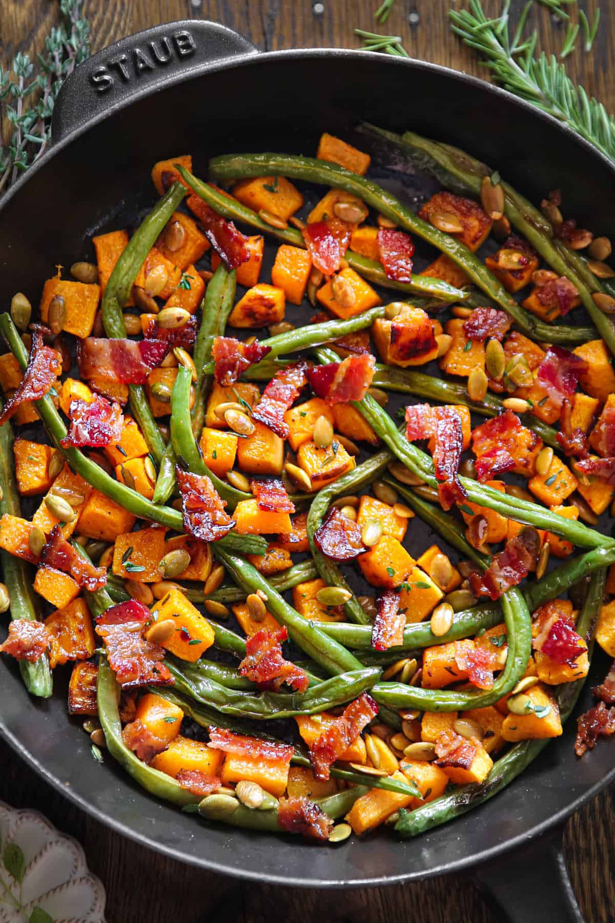 Thanksgiving Roasted Vegetables (Butternut Squash and Green Beans) with Bacon and Pumpkin Seeds in a cast iron skillet.