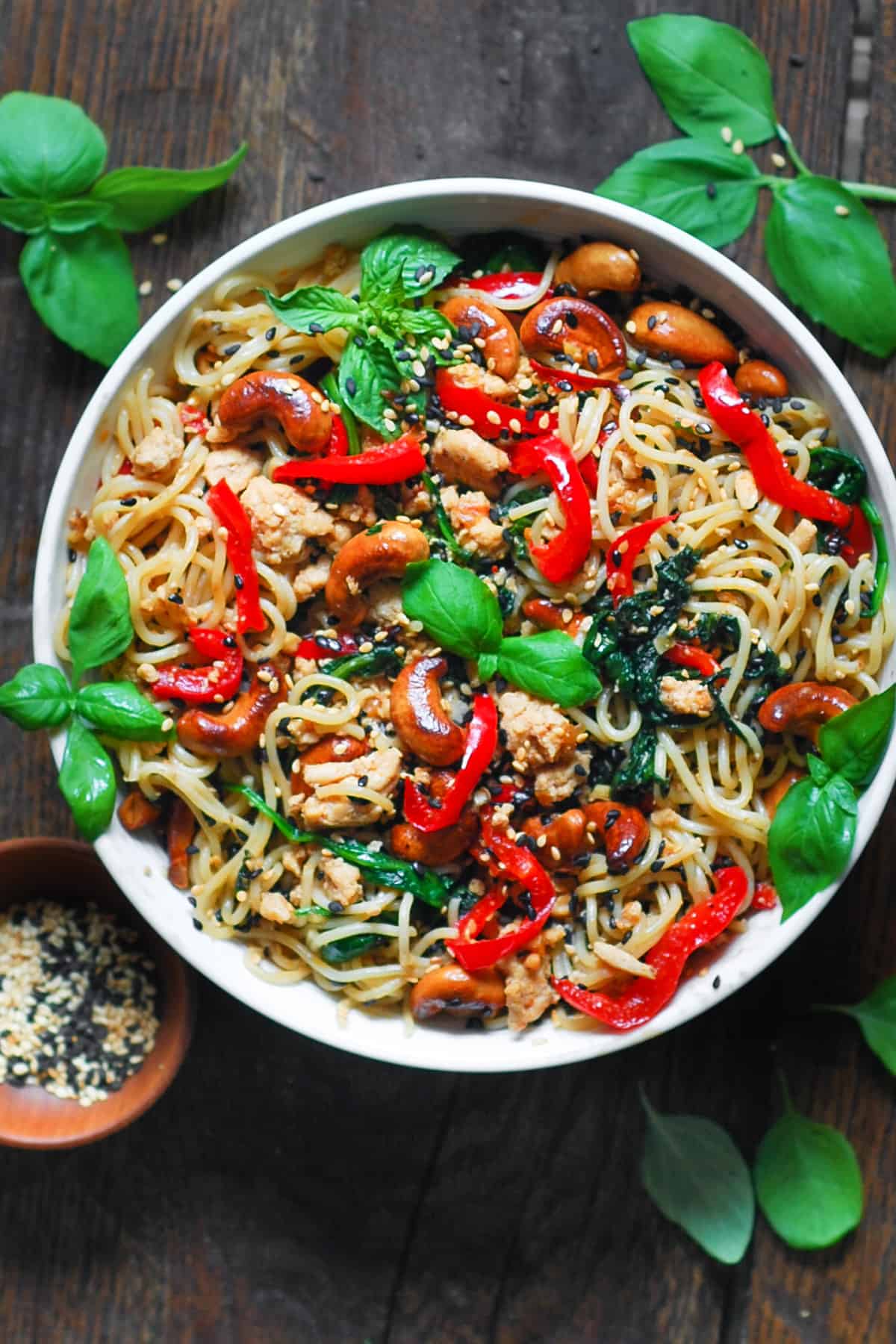 Chicken Ramen Noodles with Bell Peppers, Spinach, Cashews, and Sesame Seeds - in a white bowl.