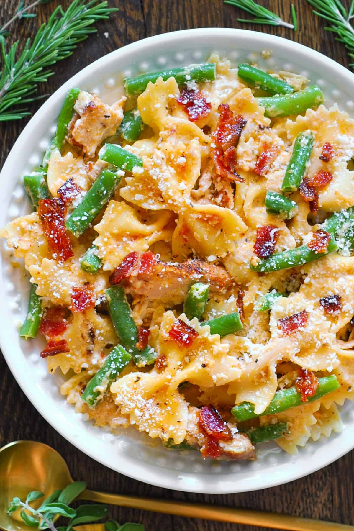 Creamy Chicken Pasta with Green Beans and Bacon on a white plate.