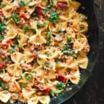 Creamy Sausage and Kale Pasta with Sun-Dried Tomatoes in a cast iron skillet.