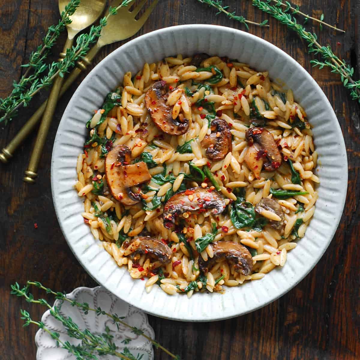 Creamy Spinach and Mushroom Orzo - on a white plate.