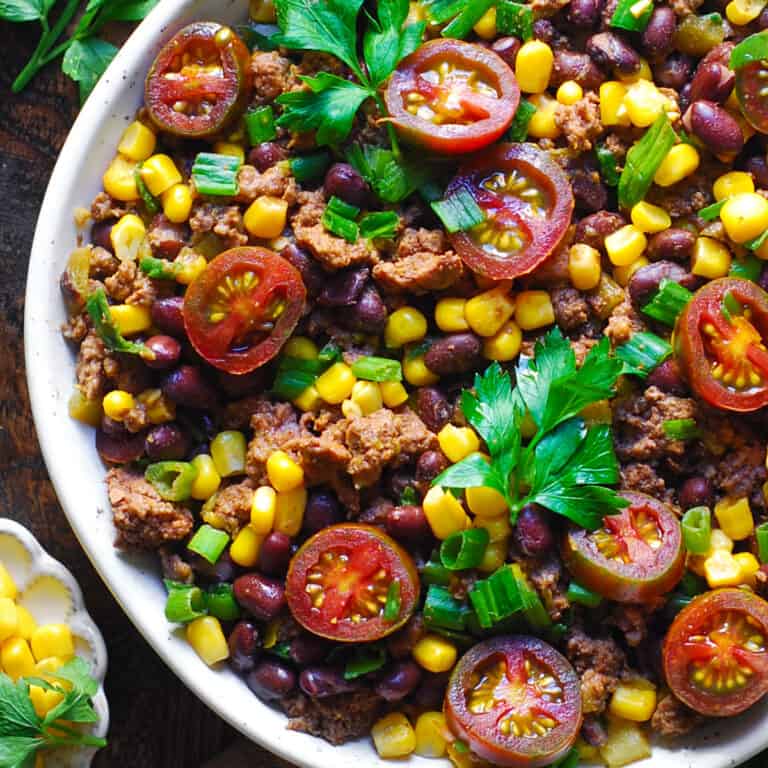 Mexican Ground Beef with Tomatoes, Corn, Black Beans, Green Onions, Green Chiles in a white bowl.