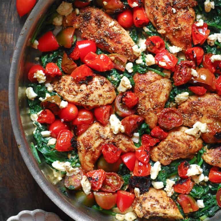 Mediterranean Chicken Stir Fry with Vegetables (Tomatoes and Spinach) and Feta Cheese - in a stainless steel pan.
