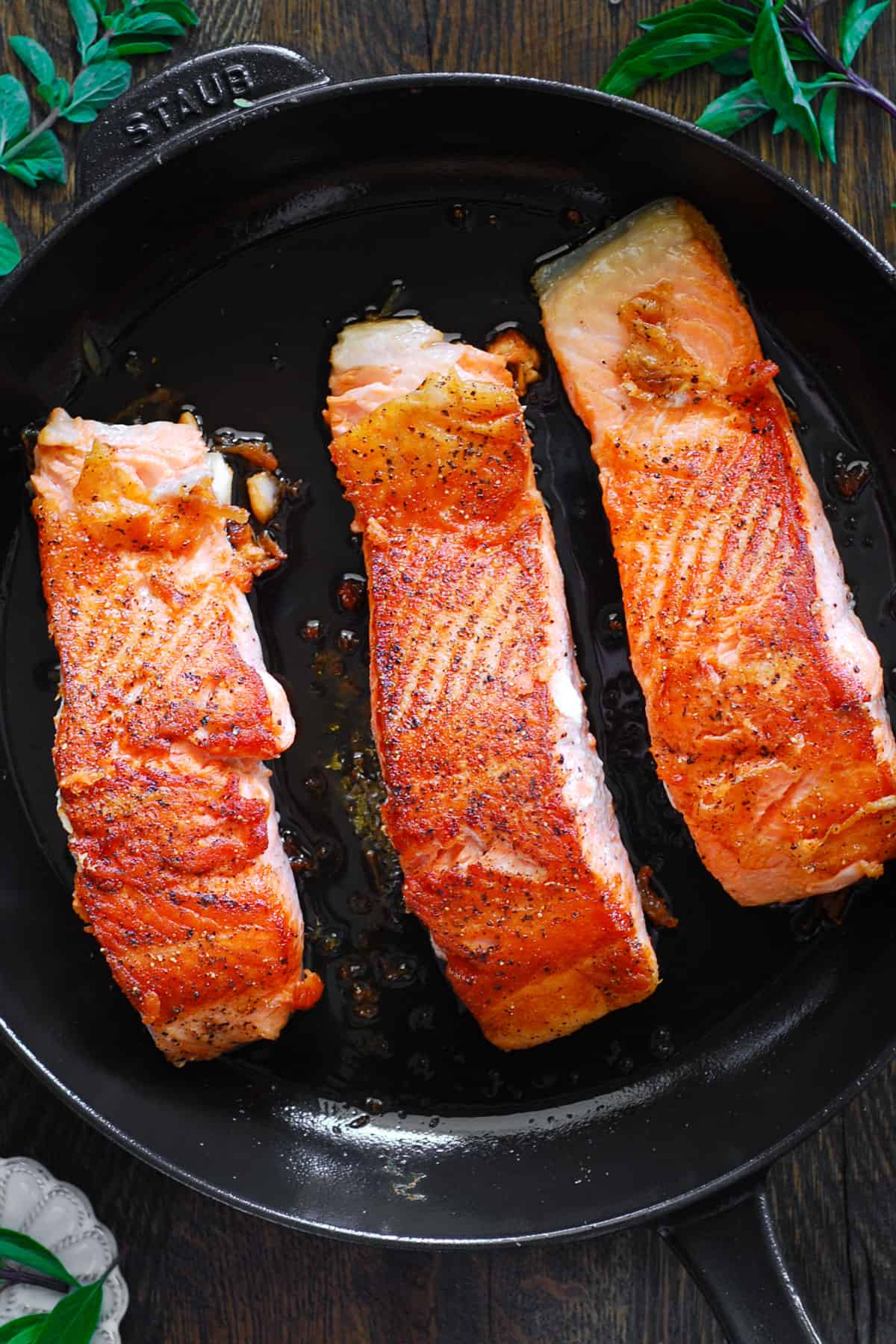 3 pan-seared salmon fillets - in a cast iron skillet.
