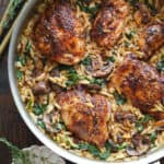 creamy chicken orzo with mushrooms and spinach - in a stainless steel pan.
