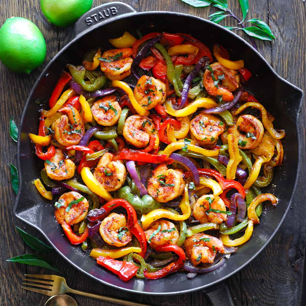 shrimp fajiitas with bell peppers and red onions - in a cast iron skillet.
