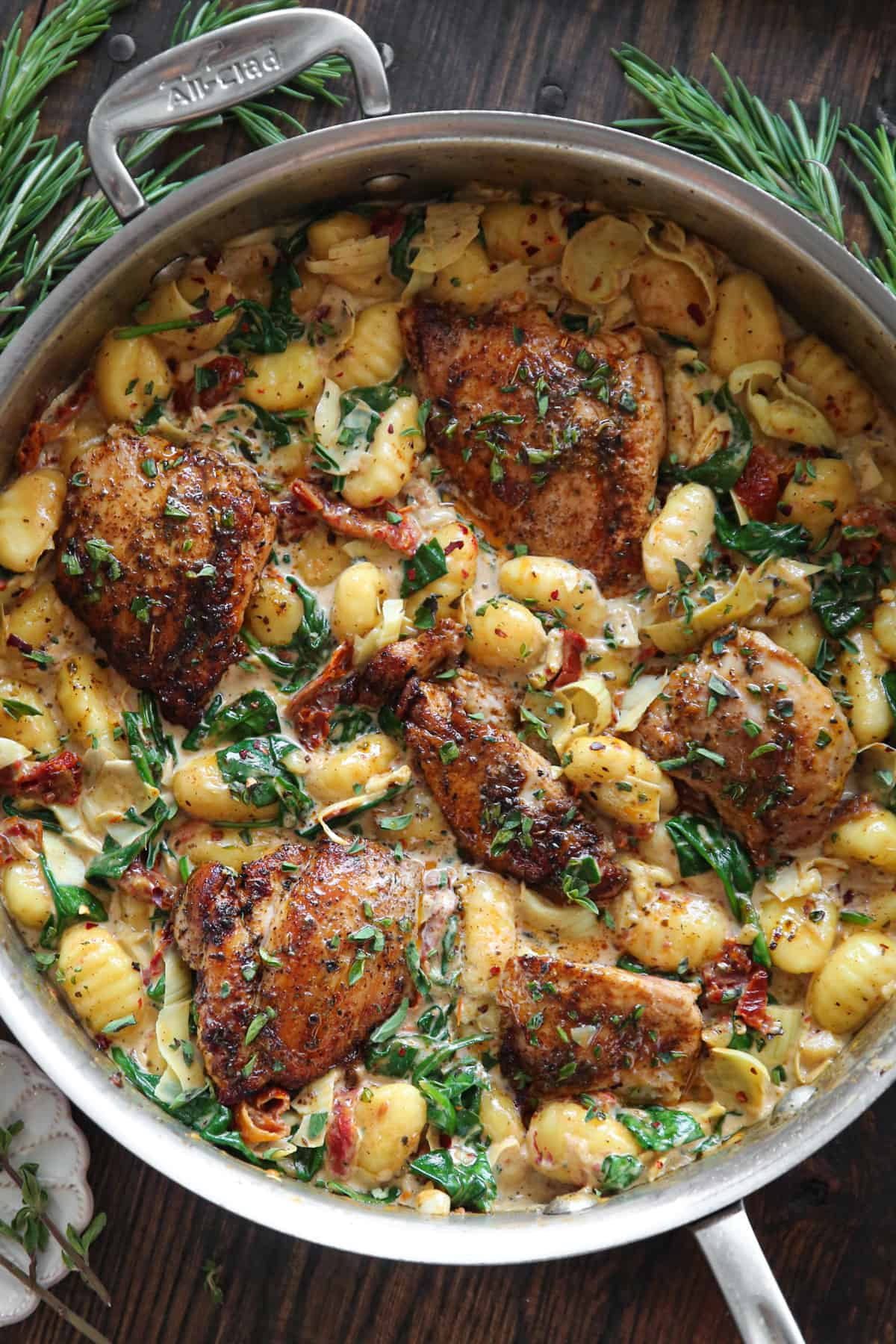 Creamy Chicken and Gnocchi with Sun-Dried Tomatoes, Spinach, and Artichokes - in a stainless steel pan.