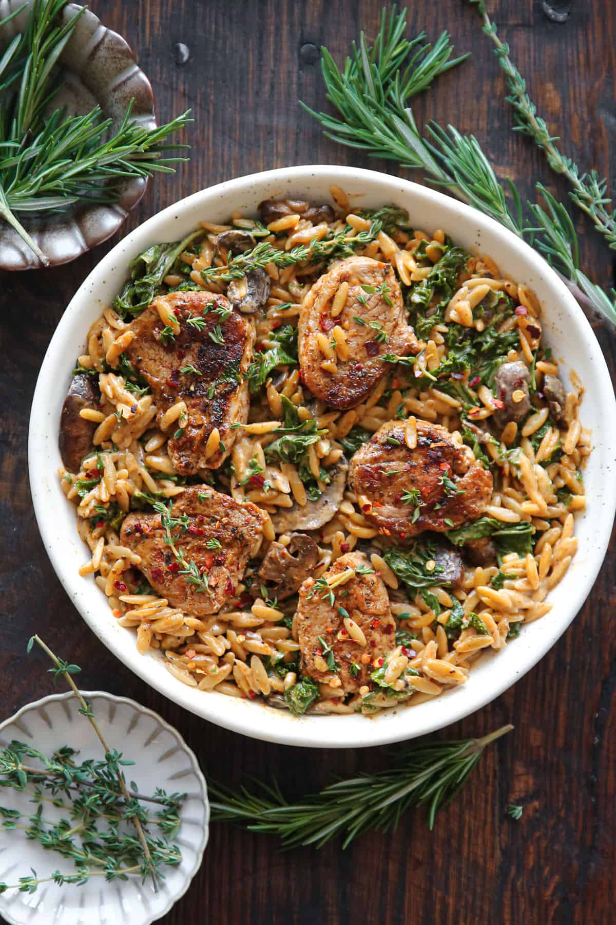 Creamy Pork Tenderloin Medallions with Orzo, Spinach, and Mushrooms - on a white plate.