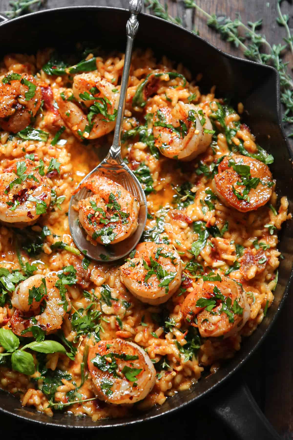 Shrimp Risotto with Spinach and Sun-Dried Tomatoes in a cast iron pan.