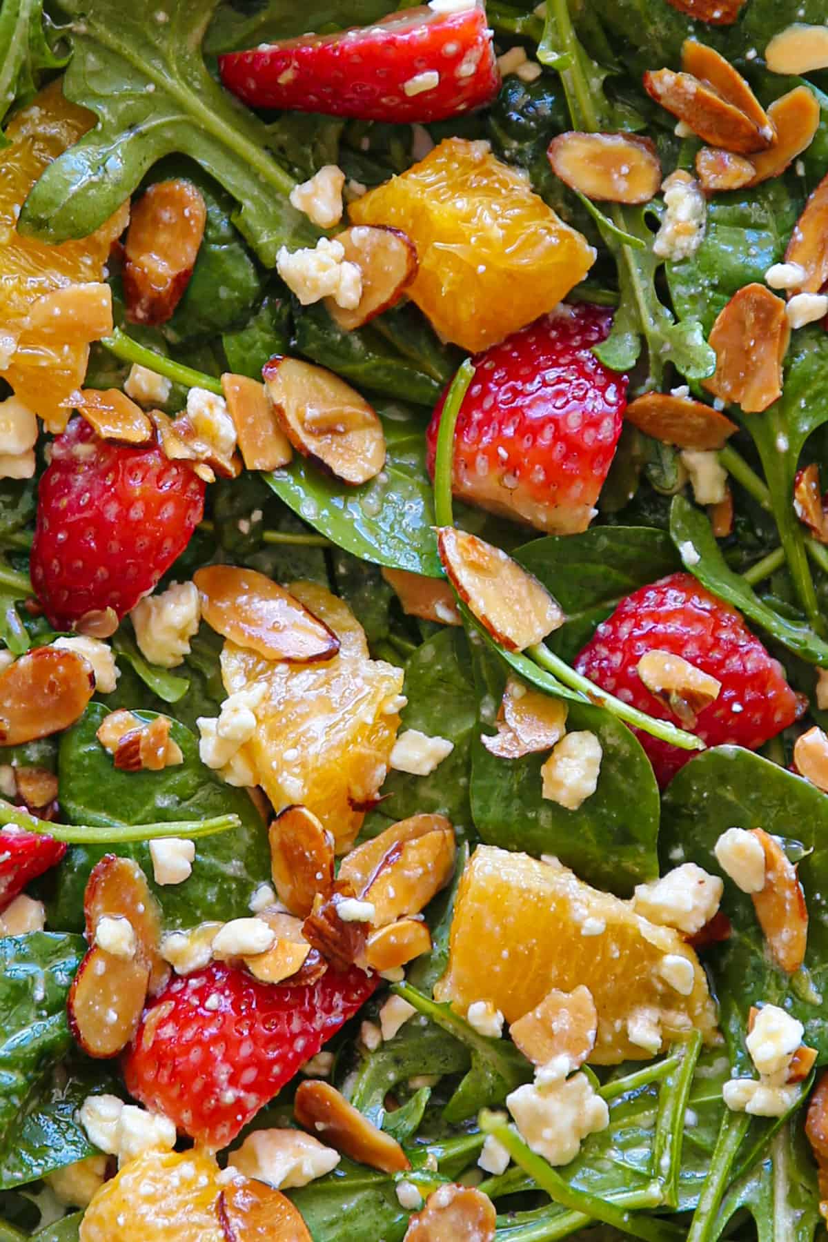 Strawberry Orange Salad with Spinach, Arugula, Toasted Sliced Almonds, and Feta Cheese (close-up).
