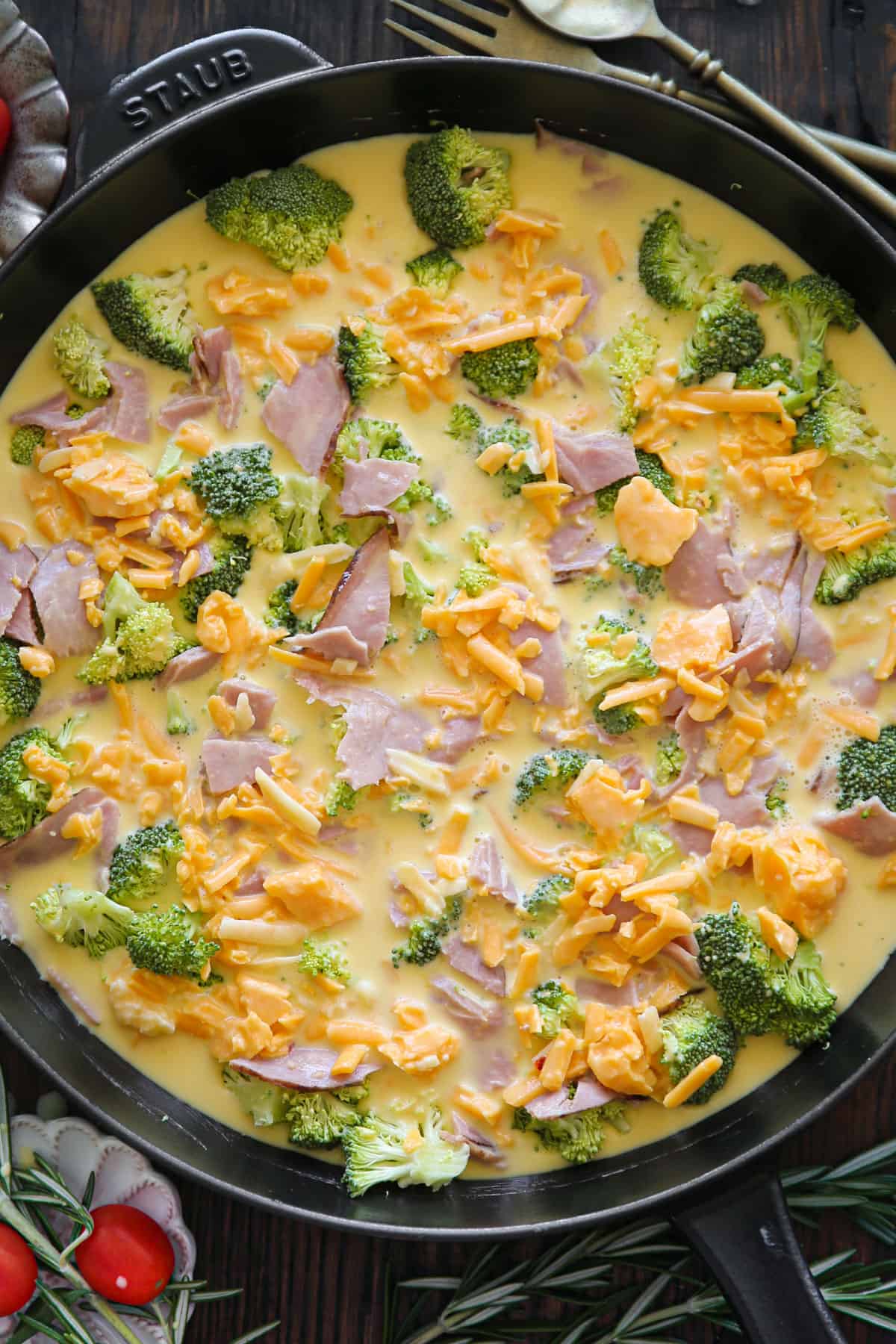 broccoli, ham, shredded cheddar cheese, and egg mixture in a cast iron skillet.