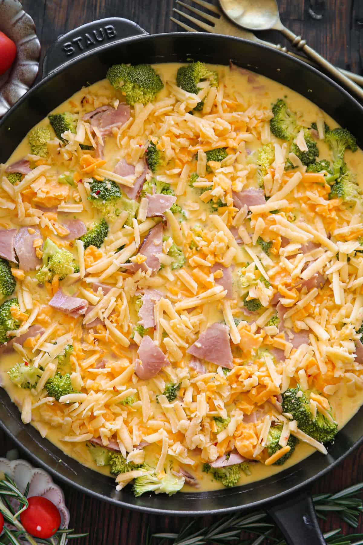 broccoli, ham, shredded cheddar cheese, pepper jack cheese, and egg mixture in a cast iron skillet.