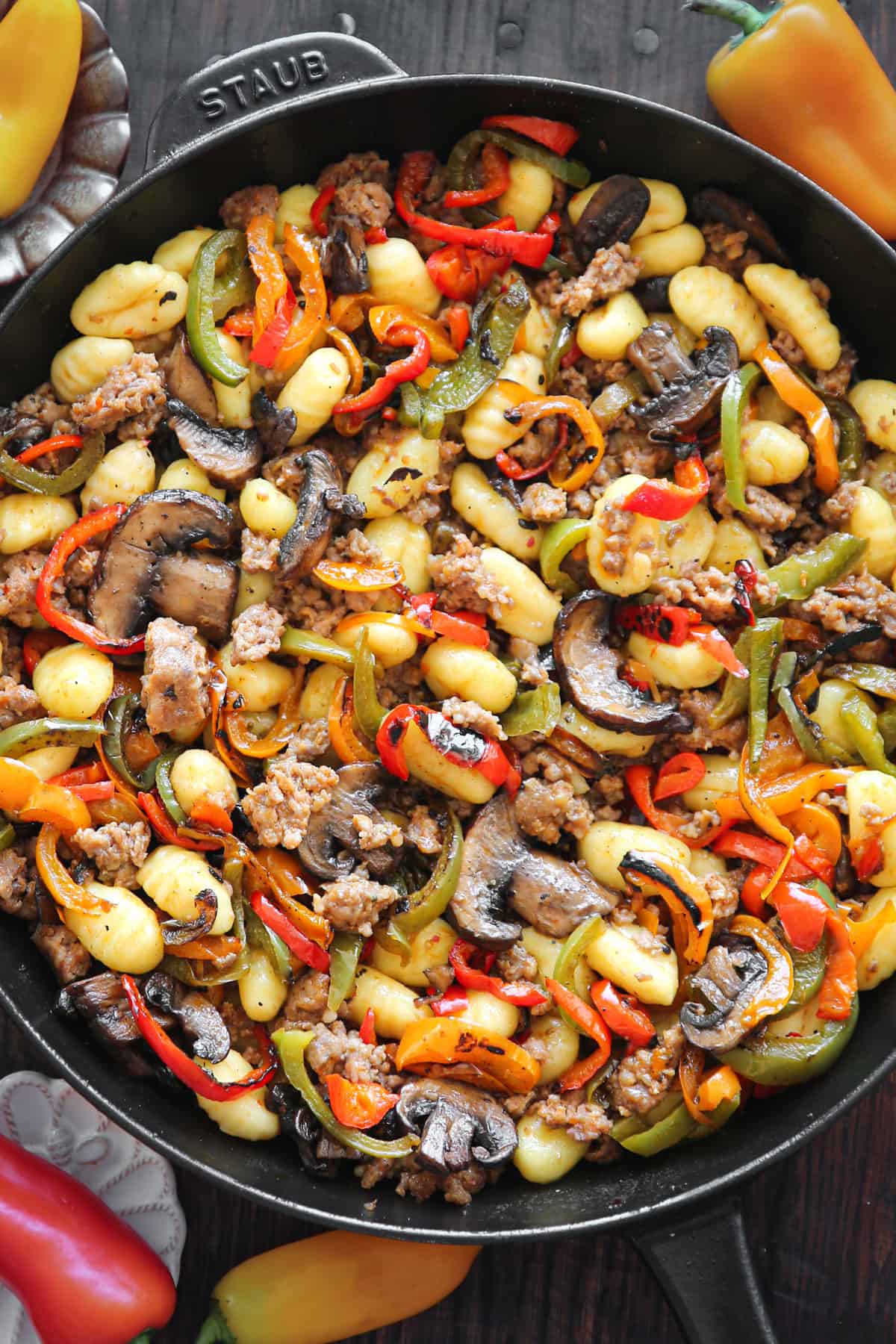 sausage gnocchi with mushrooms and bell peppers in a cast iron skillet.