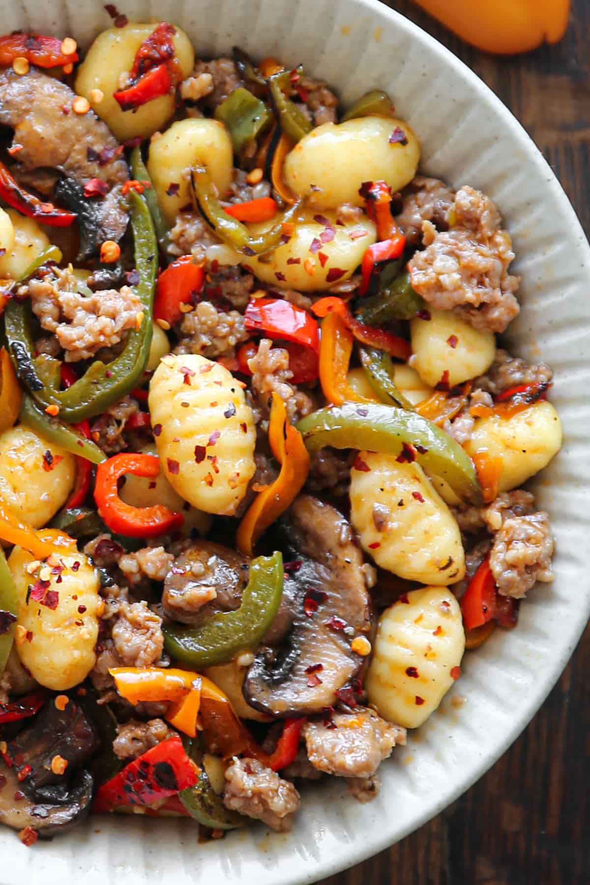 Spicy Italian Sausage Gnocchi with Mushrooms and Bell Peppers - in a white bowl.