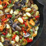 Spicy Italian Sausage Gnocchi with Mushrooms and Bell Peppers - in a cast iron skillet.
