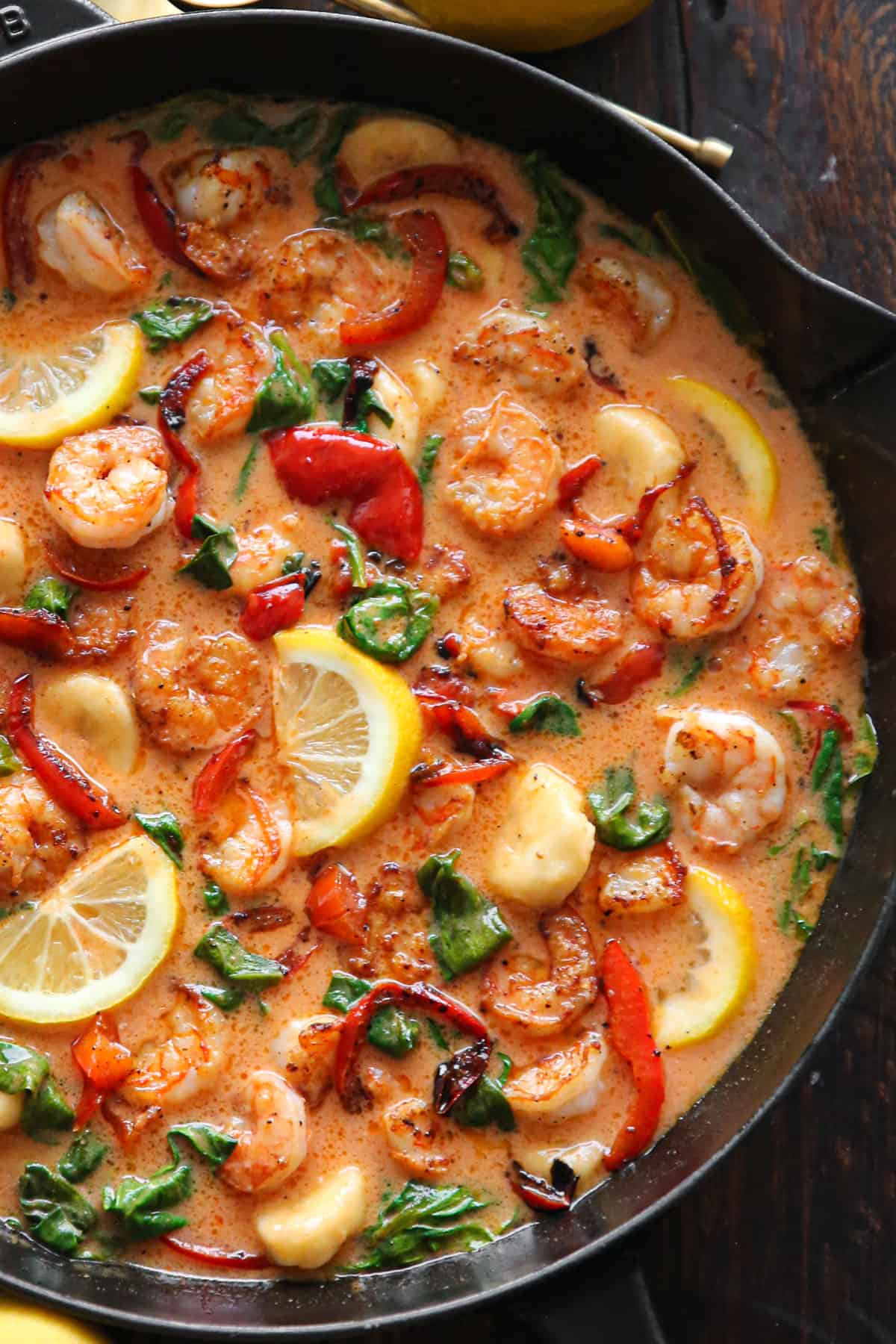 Red Coconut Curry Shrimp with Bananas, Bell Peppers, and Spinach - in a cast iron skillet.