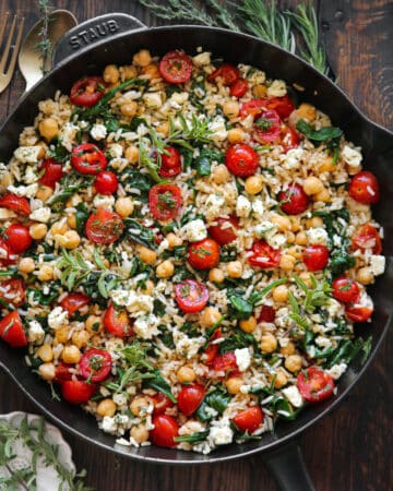 Mediterranean Lemon Rice with Chickpeas, Tomatoes, and Feta - in a cast iron skillet.