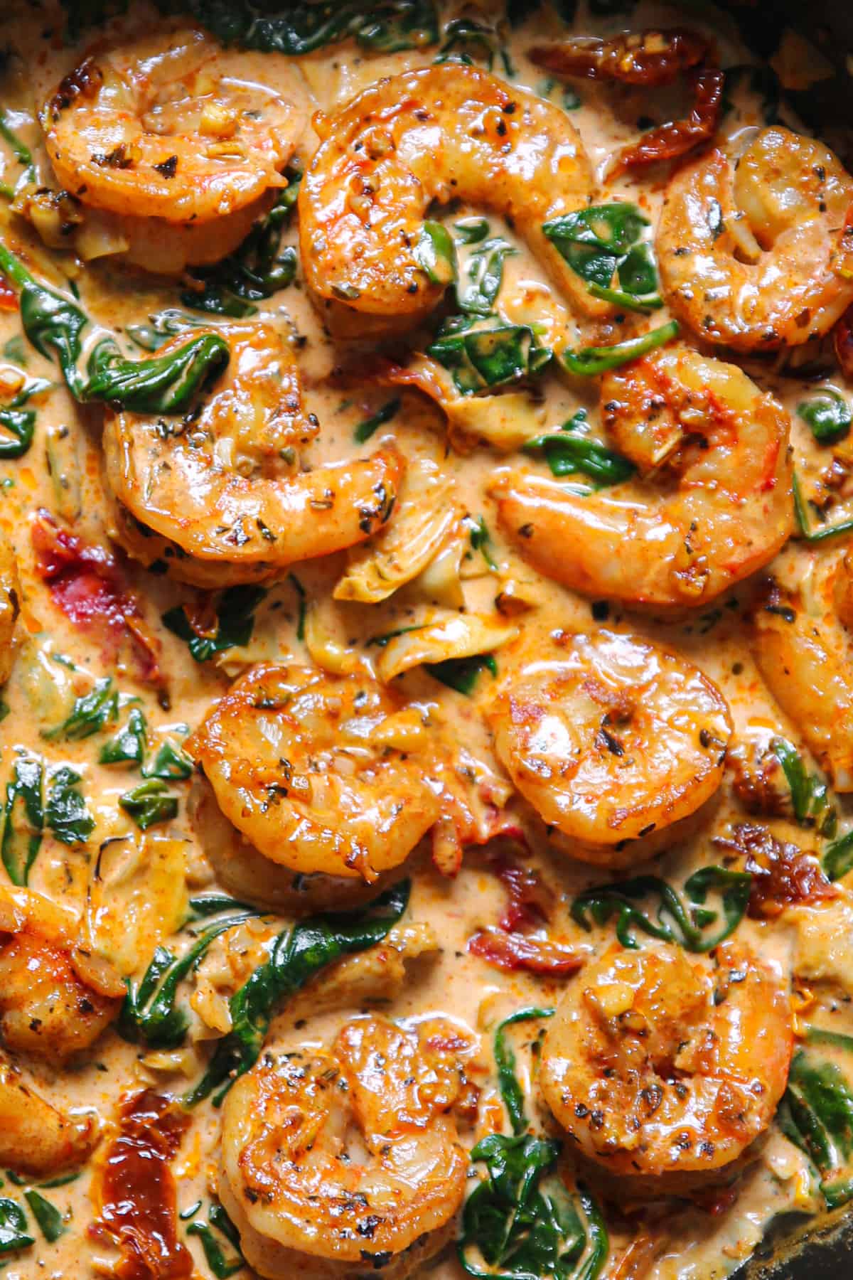 Creamy Tuscan Shrimp with Sun-Dried Tomatoes, Spinach, and Artichokes - close-up photo.
