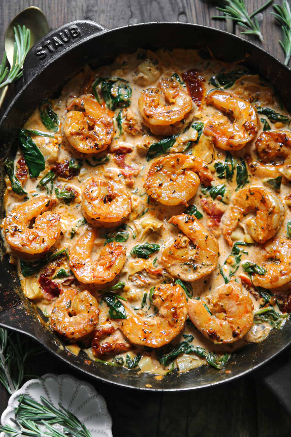 Creamy Tuscan Shrimp with Sun-Dried Tomatoes, Spinach, and Artichokes - in a cast iron skillet.