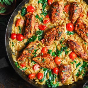 Creamy Chicken Orzo with Tomatoes and Spinach - in a cast iron skillet.