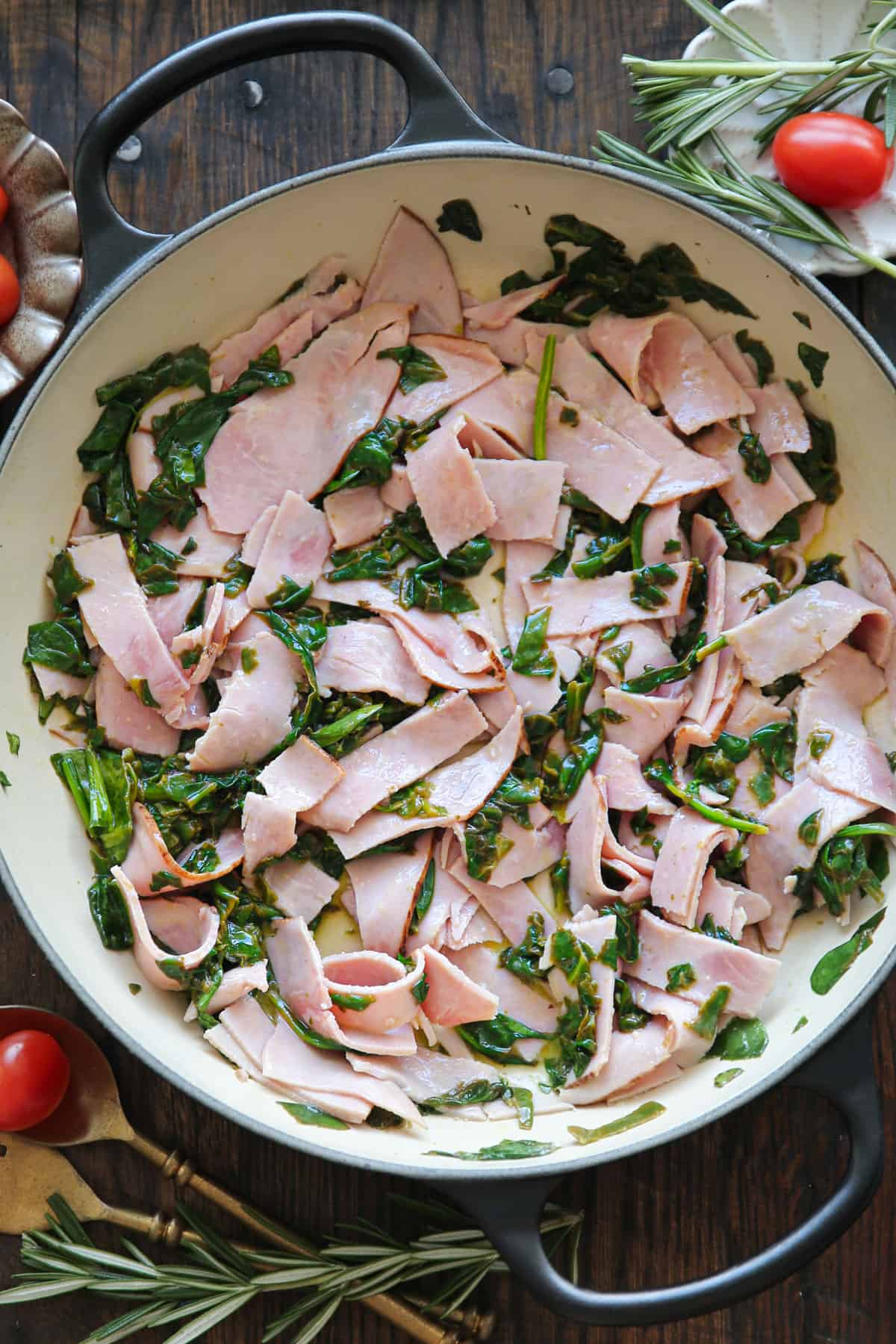 cooked spinach with sliced ham - in a cooking pan.