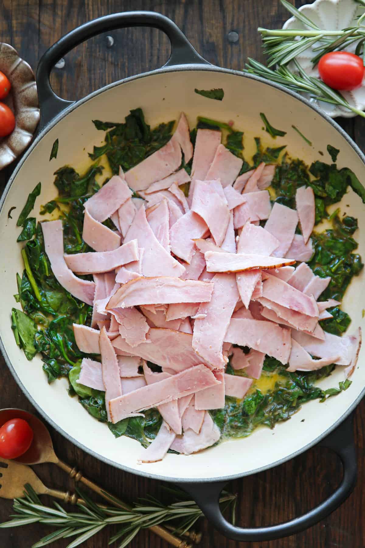 cooked spinach with sliced ham - in a cooking pan.