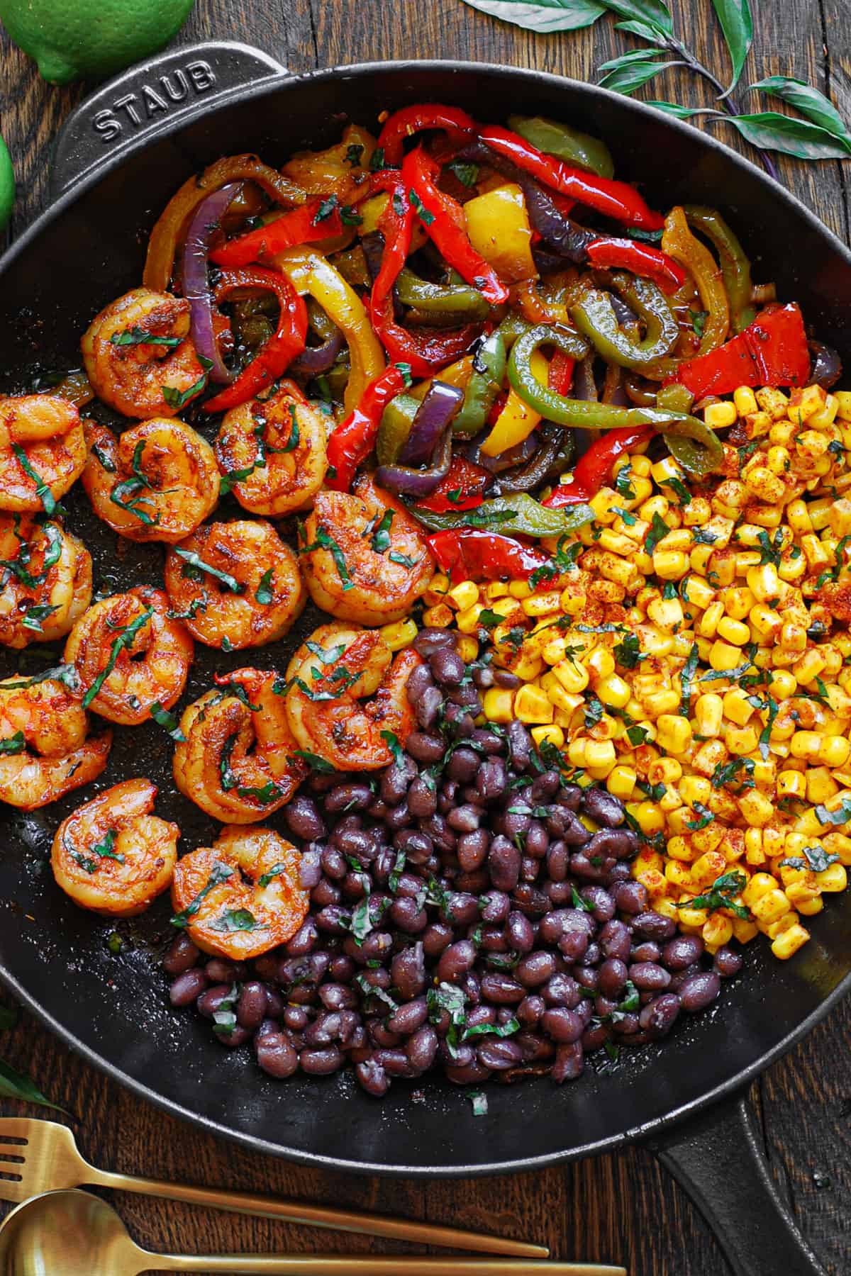 Shrimp Fajitas with bell peppers, red onions, black beans, and corn - in a cast iron skillet.