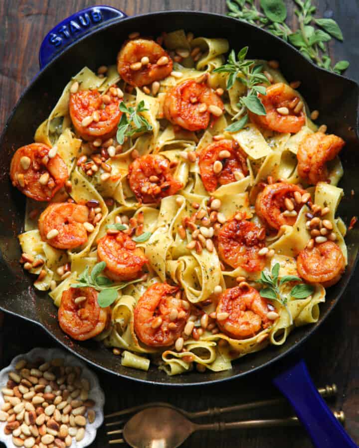 shrimp pesto pasta with pine nuts - in a cast iron skillet.