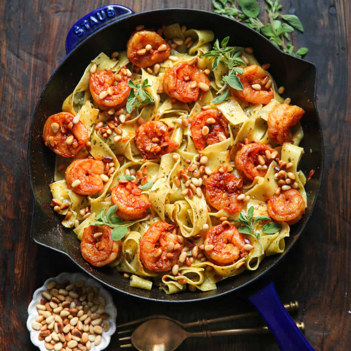 shrimp pesto pasta with pine nuts - in a cast iron skillet.