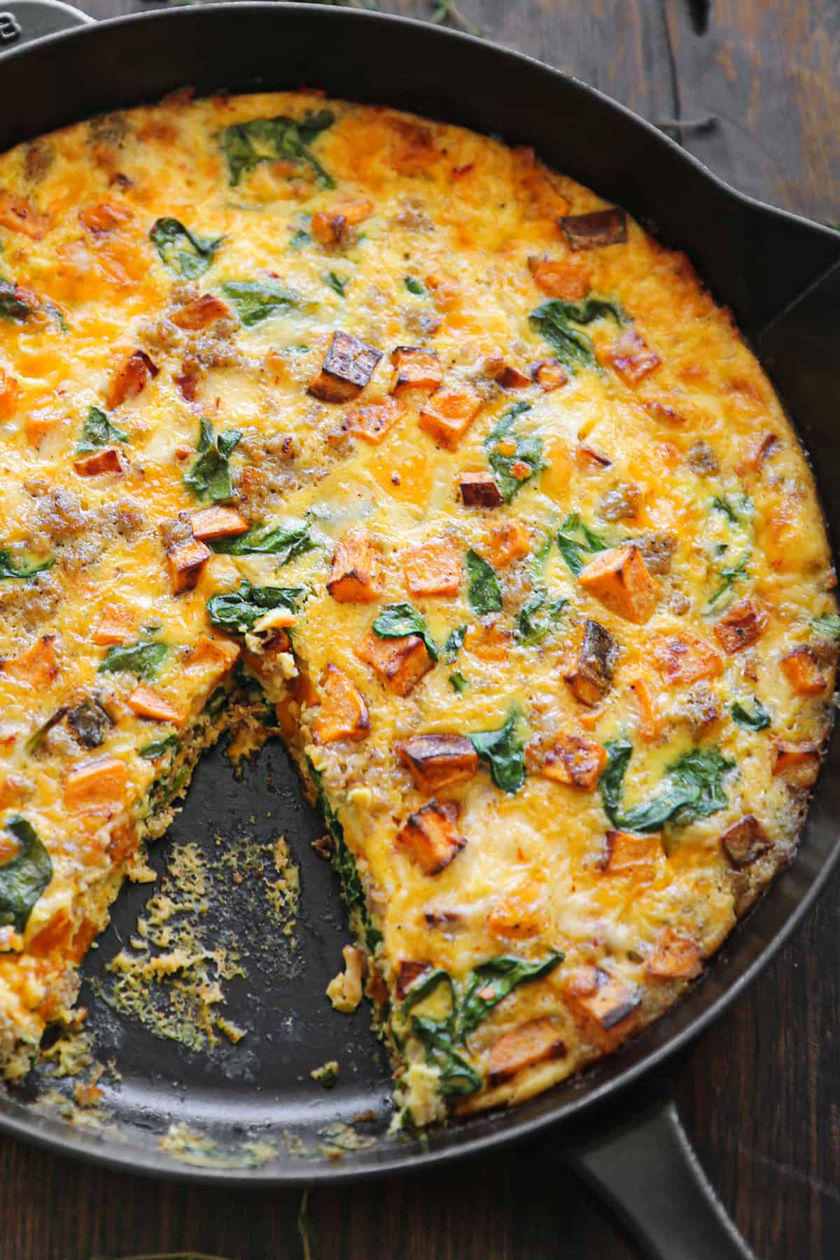 Sweet potato frittata with sausage, spinach, cheddar, and pepper jack cheese - in a cast iron skillet.