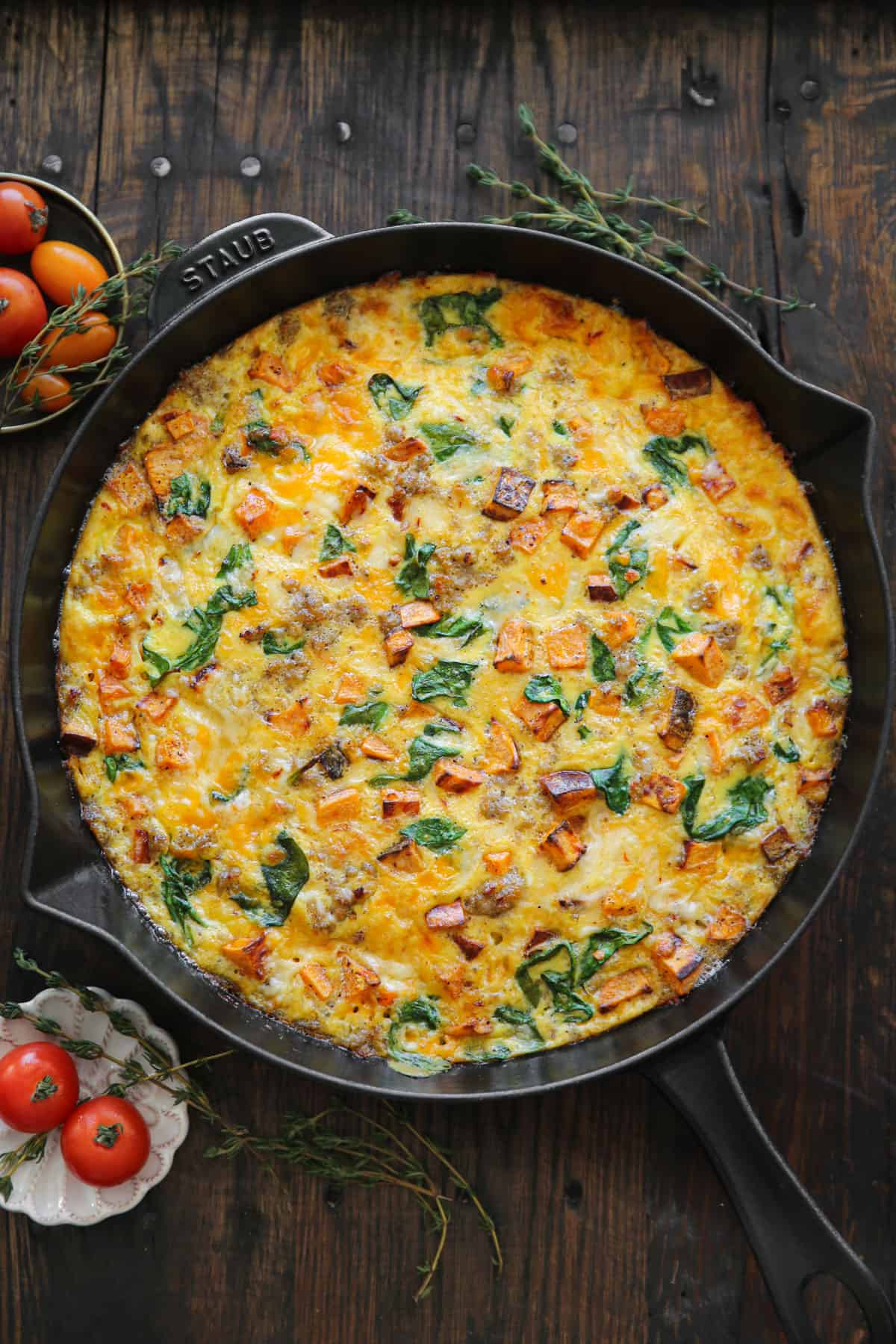Sweet potato frittata with sausage, spinach, cheddar, and pepper jack cheese - in a cast iron skillet.