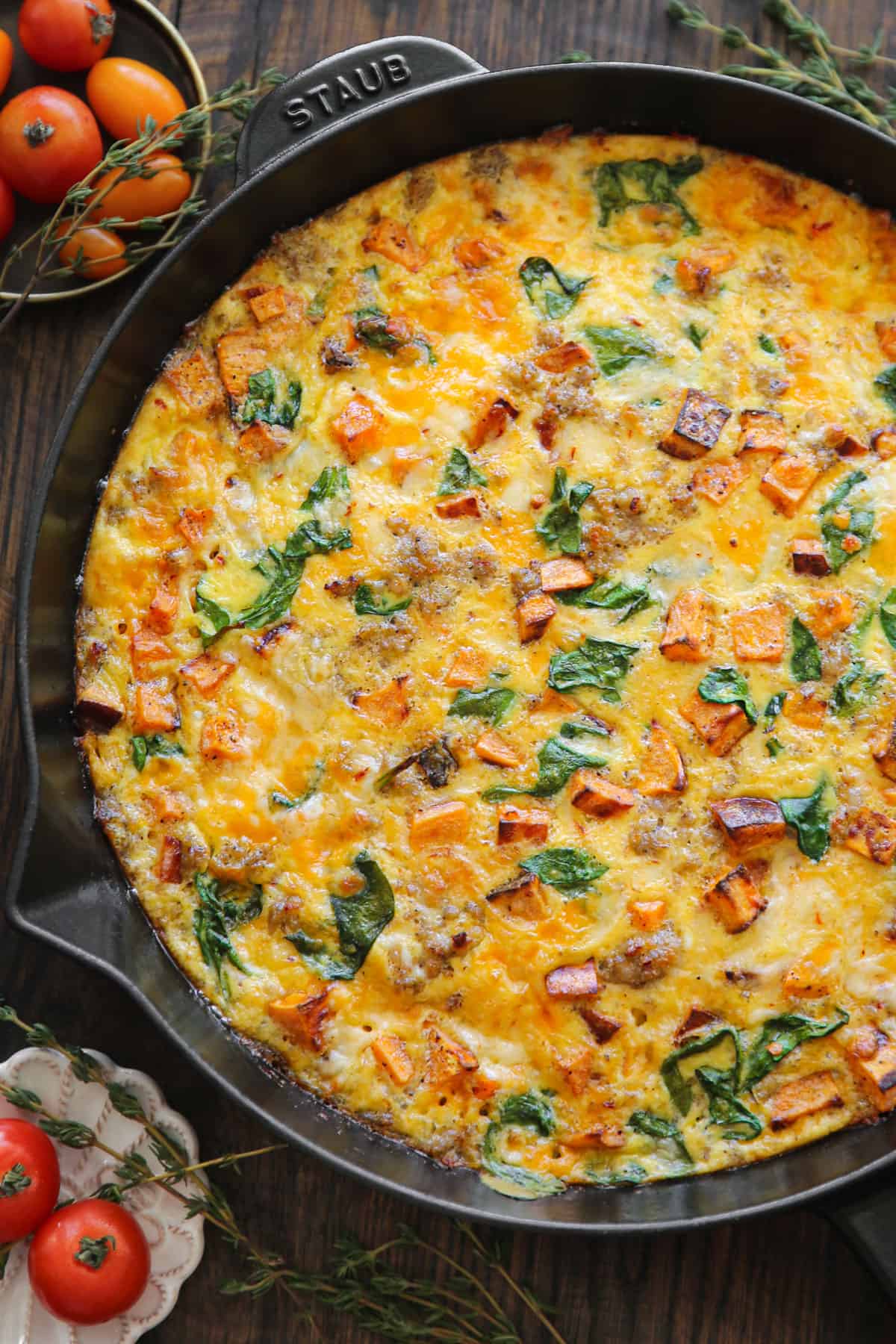 sweet potato frittata with sausage, spinach, cheddar, and pepper jack cheese - in a cast iron skillet.