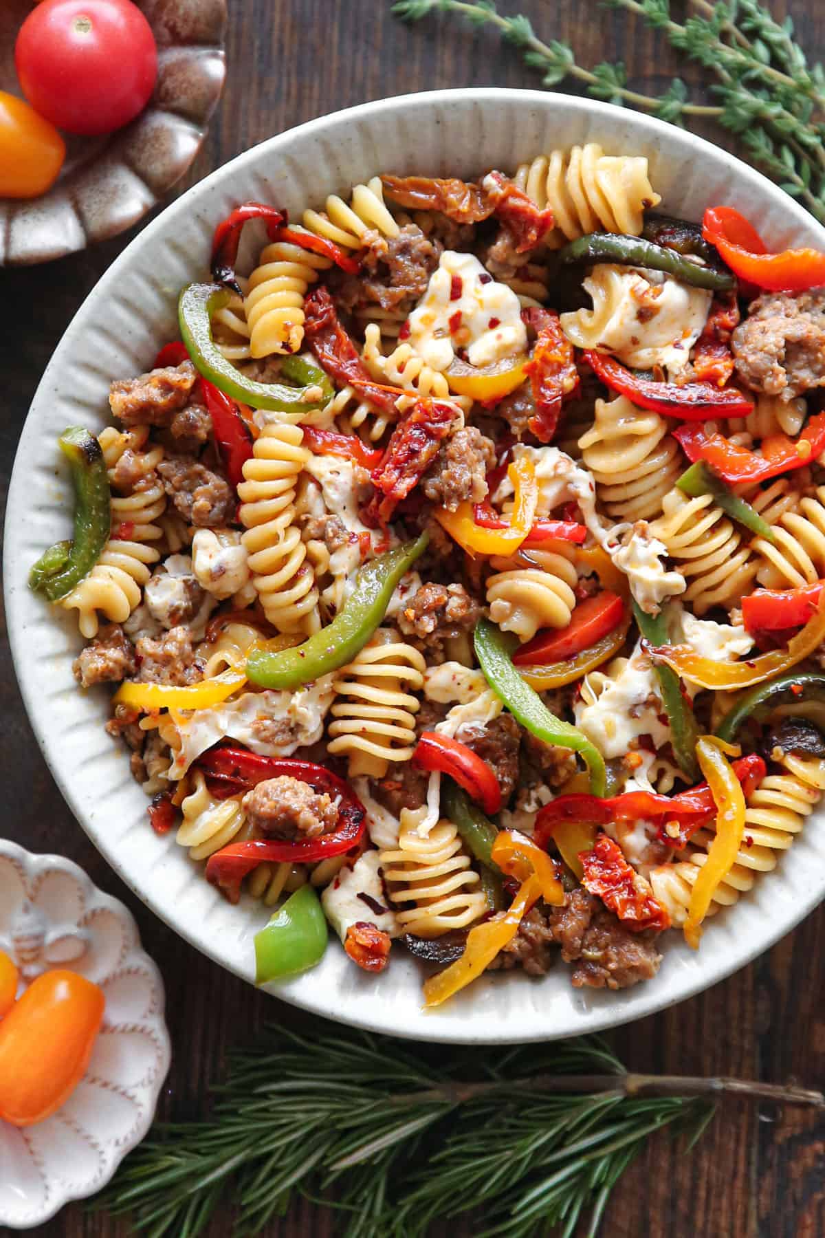 Pasta with Sausage and Peppers, Sun-Dried Tomatoes, and fresh Mozzarella cheese - in a white bowl.