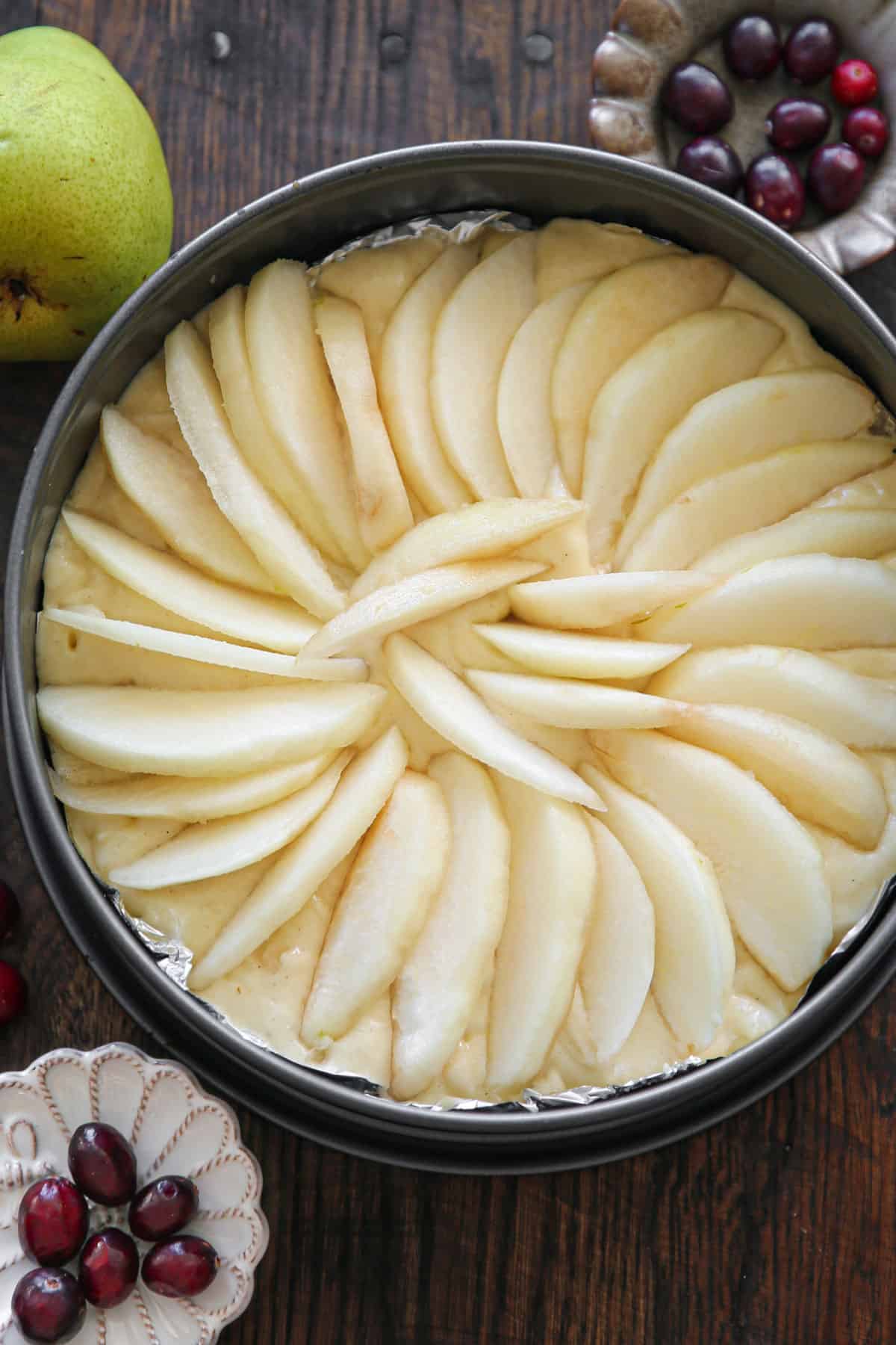cake batter with sliced pears on top - in a springform pan.