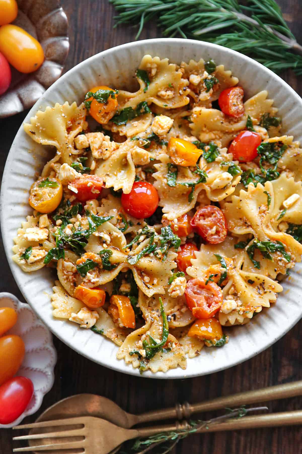 Feta Pasta (with no chicken) with bow-tie pasta, tomatoes, and spinach - in a white bowl.