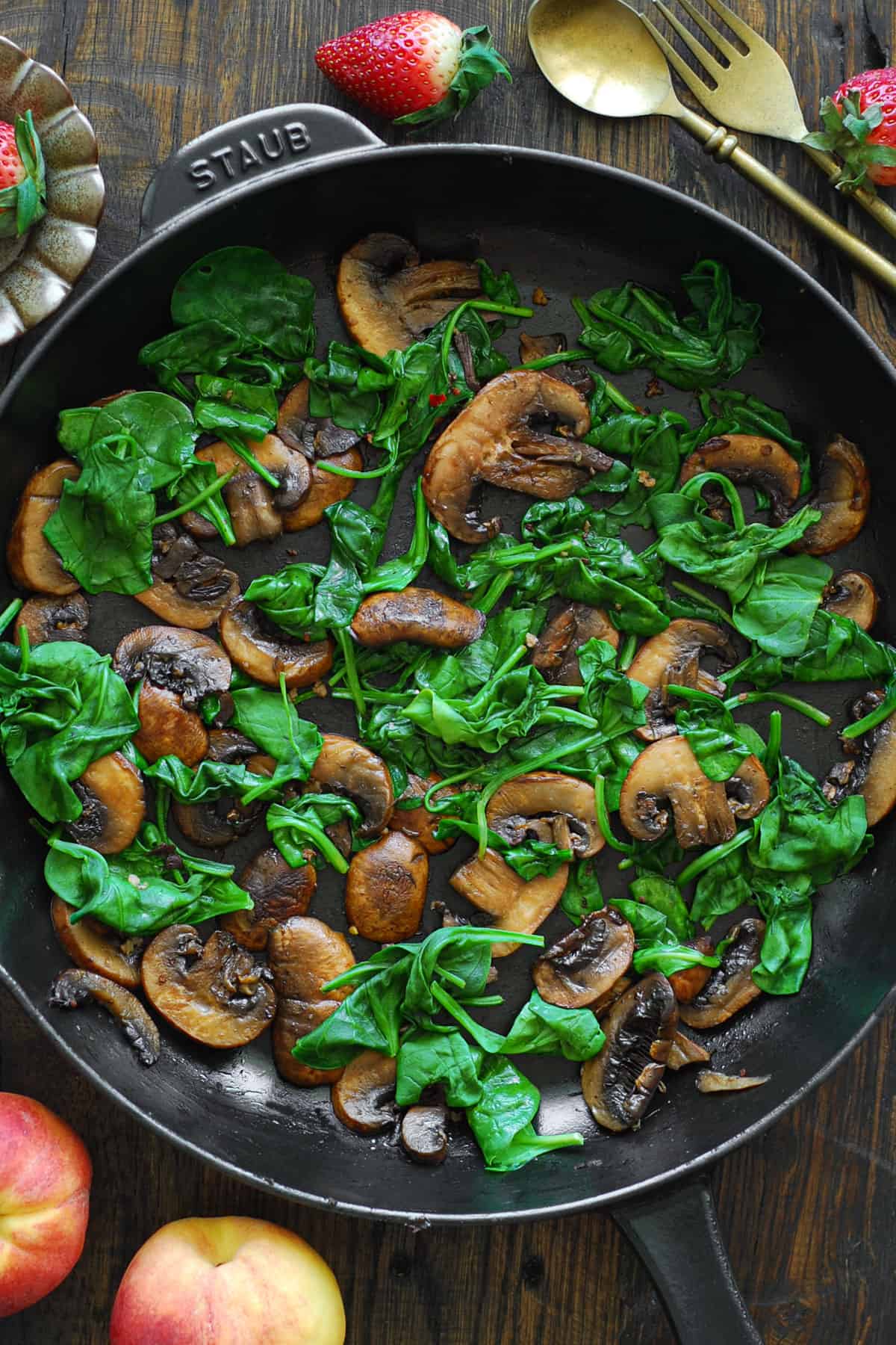 cooked mushrooms and spinach in a cast iron skillet.