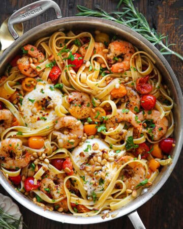 Mediterranean Shrimp Pasta with Tomatoes, Burrata Cheese, and Pine Nuts - in a stainless steel pan.