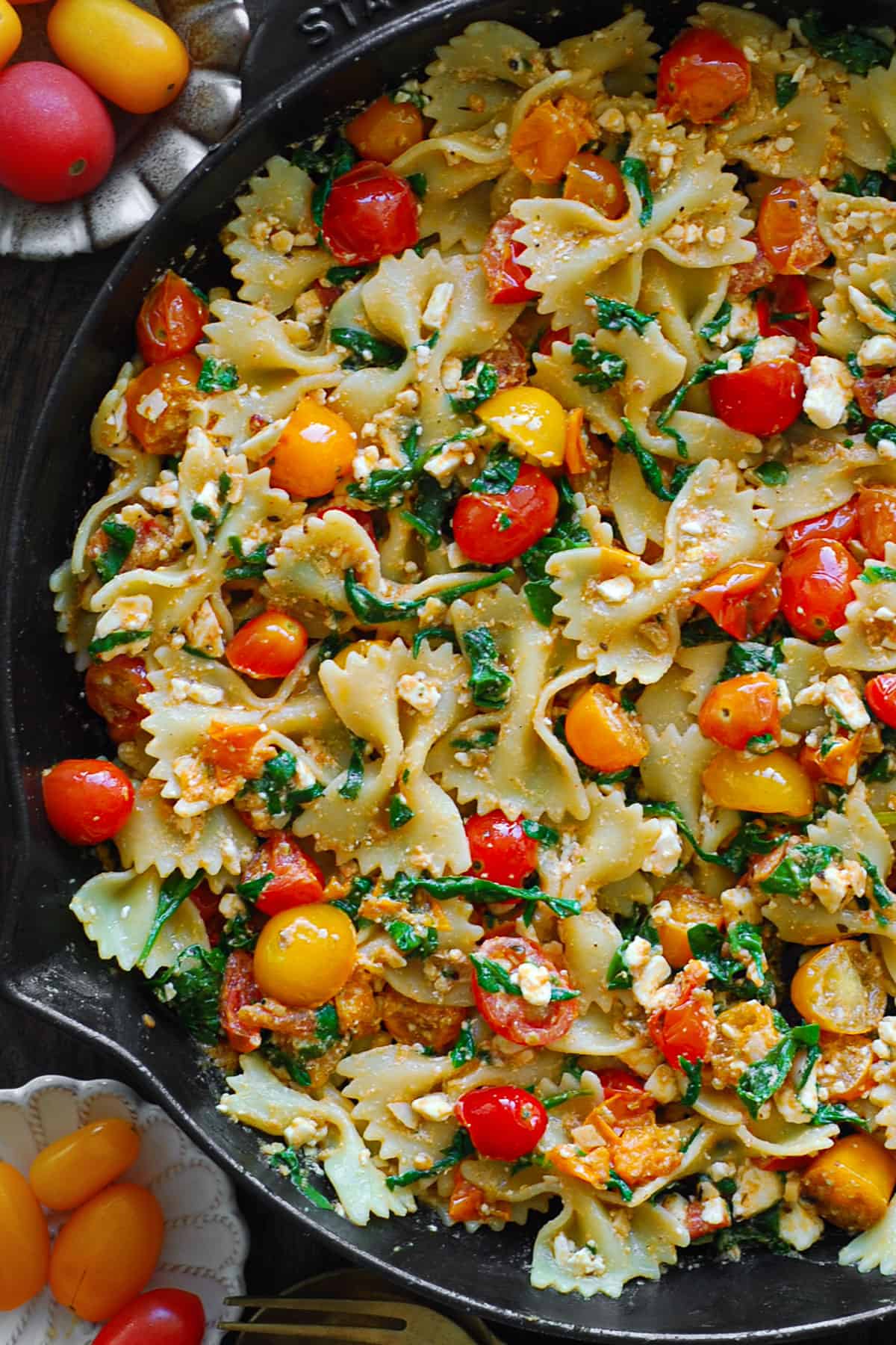 Bow-Tie Pasta with Feta Cheese, Cherry Tomatoes, and Spinach - in a cast iron skillet.
