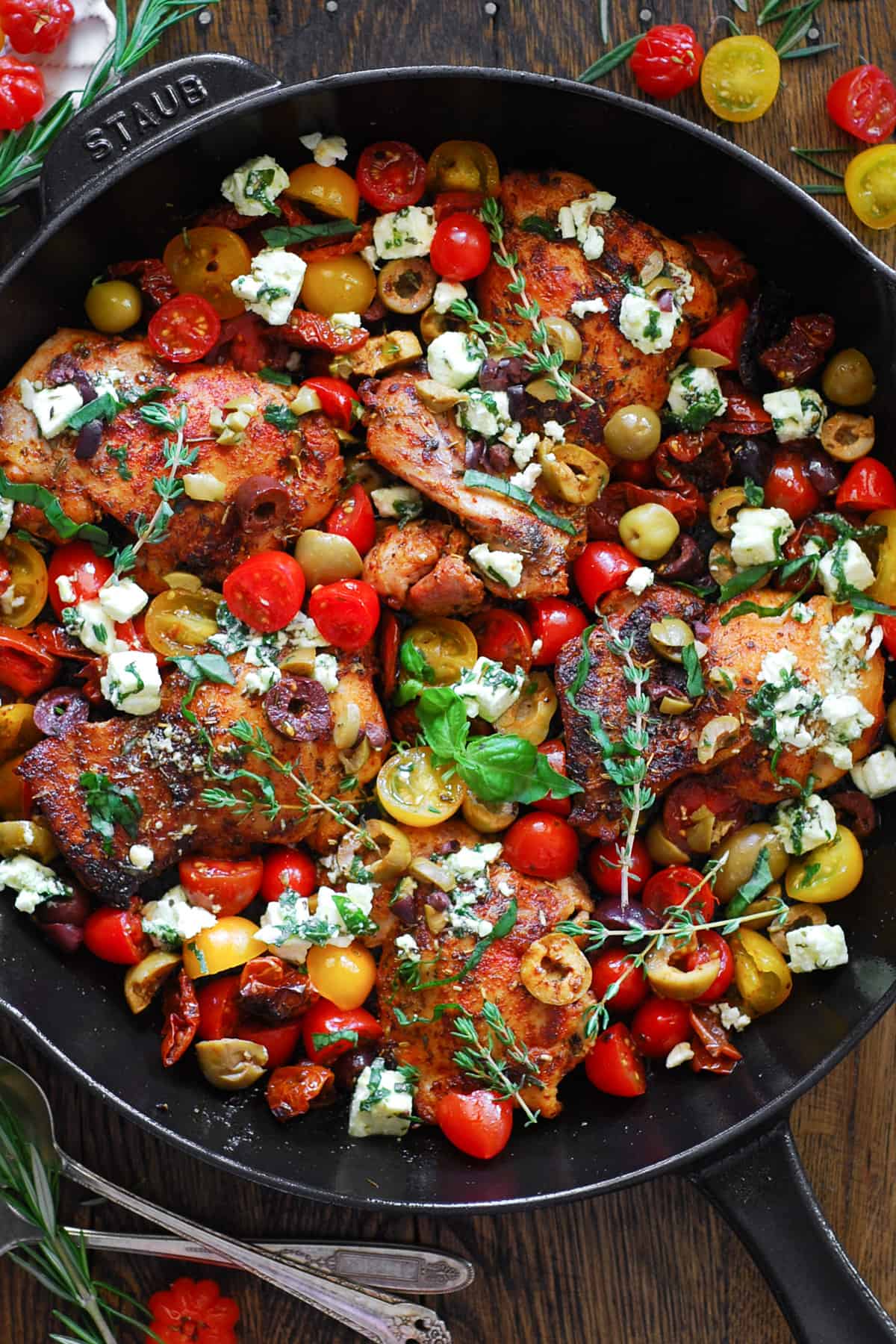 Greek Chicken with Tomatoes, Olives, Sun-Dried Tomatoes, and Feta Cheese - in a cast iron skillet.