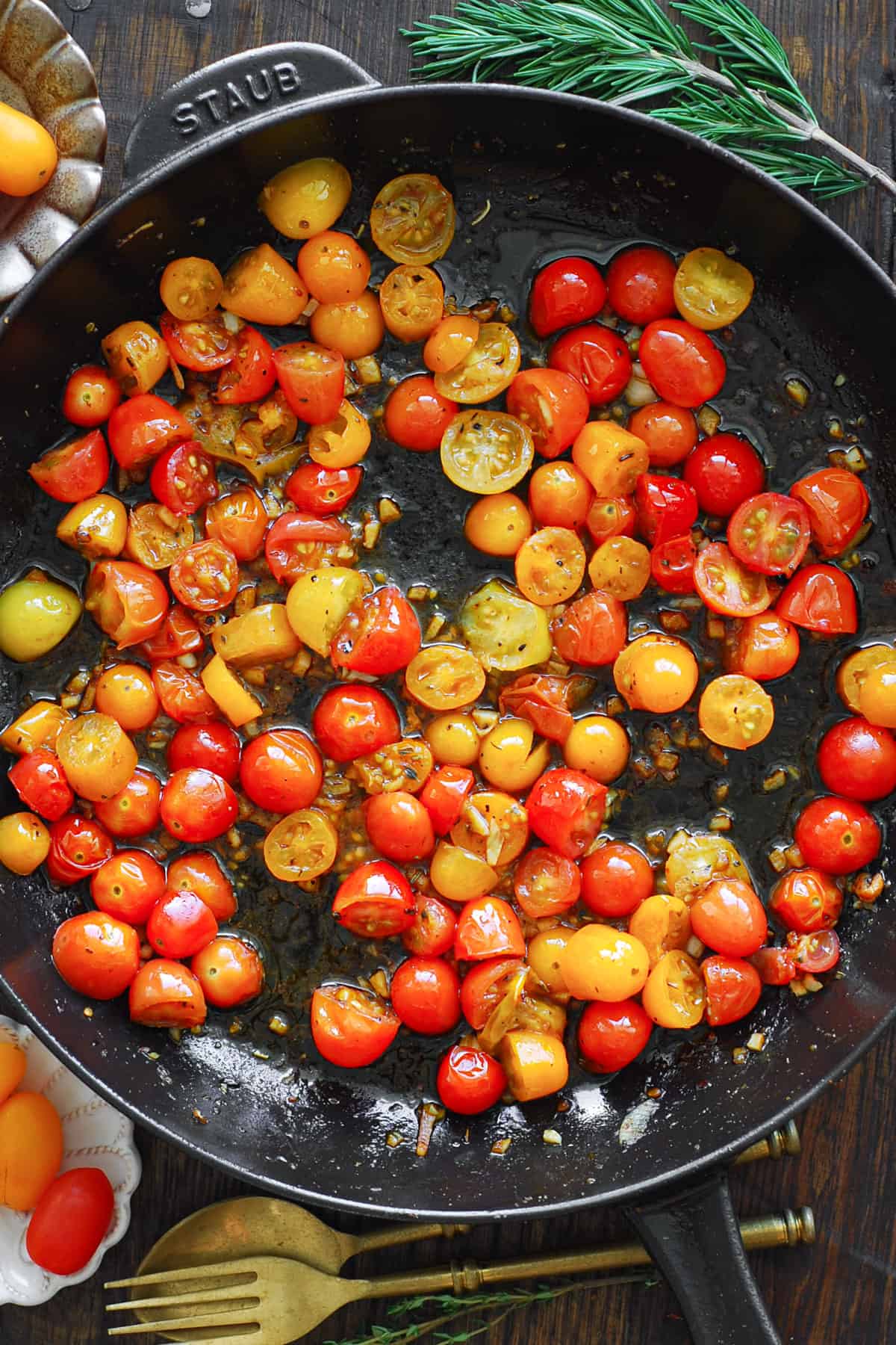 cooked cherry tomatoes in a cast iron skillet.
