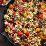 Greek orzo with tomatoes, feta and olives - in a cast iron skillet.