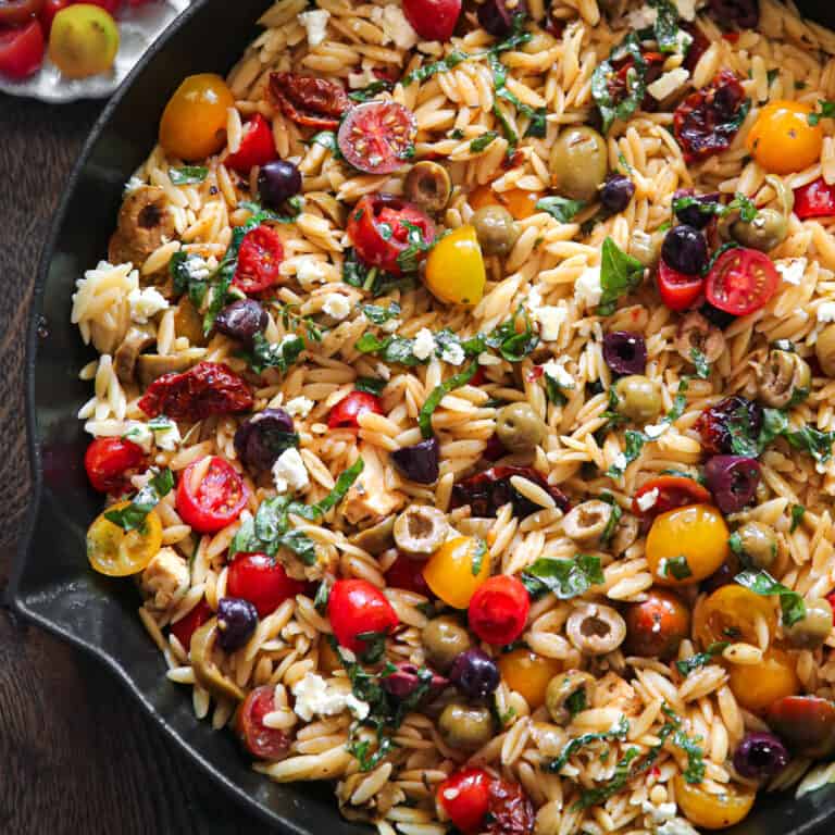 Greek Orzo with Tomatoes, Feta, and Olives - in a cast iron skillet.