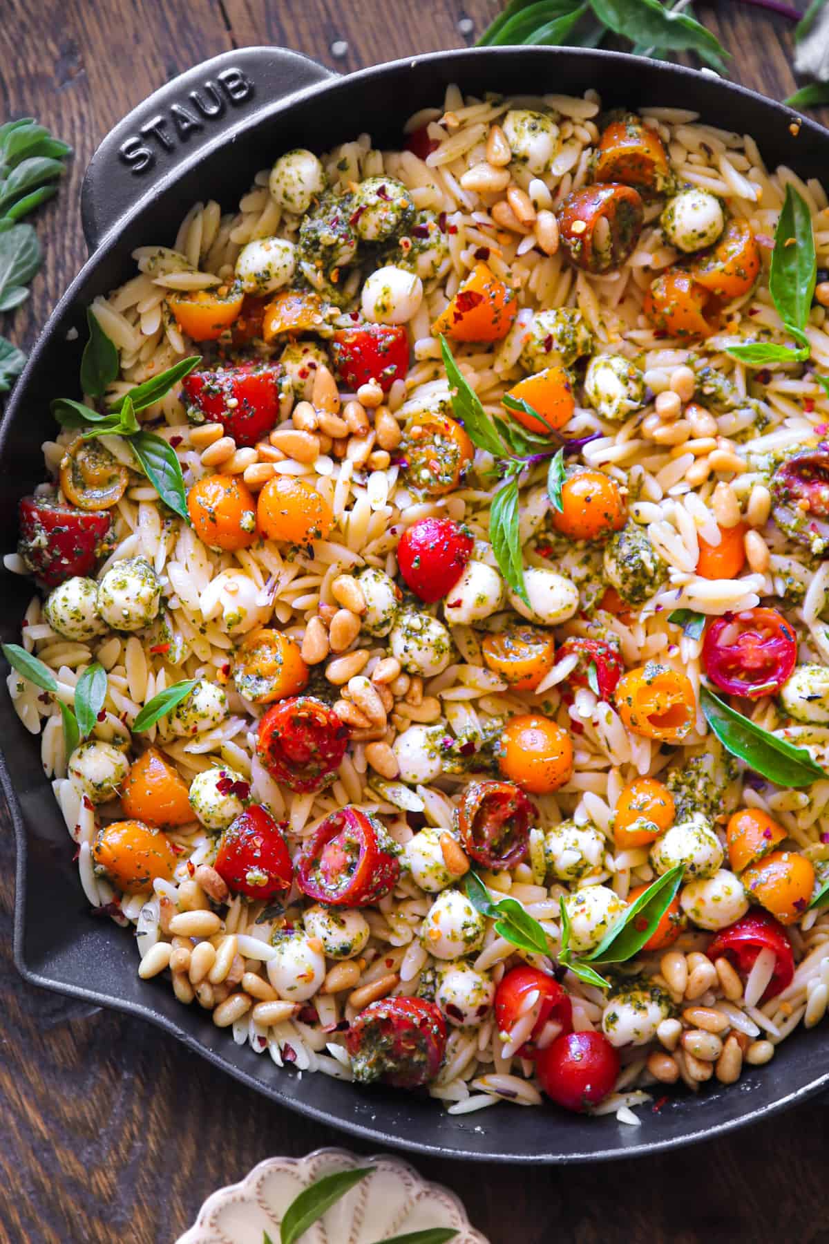 Pesto Orzo with Tomatoes, Mozzarella Cheese, and Pine Nuts - in a cast iron skillet.