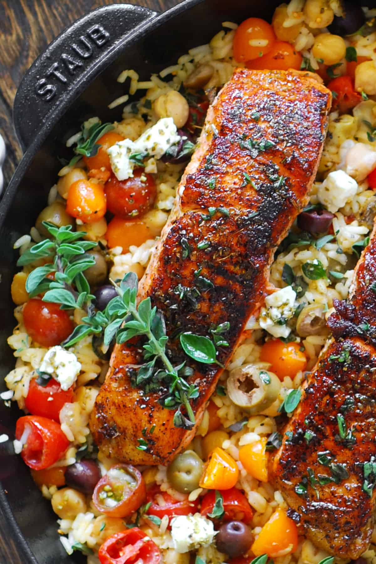 Mediterranean Salmon with Rice, Chickpeas, Cherry Tomatoes, Olives, and Feta Cheese - in a cast iron skillet.