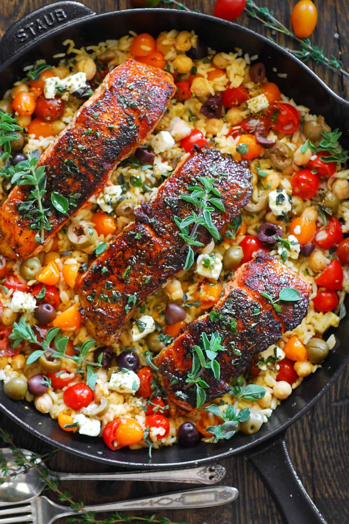 Mediterranean Salmon with Rice, Chickpeas, Cherry Tomatoes, Olives, and Feta Cheese - in a cast iron skillet.