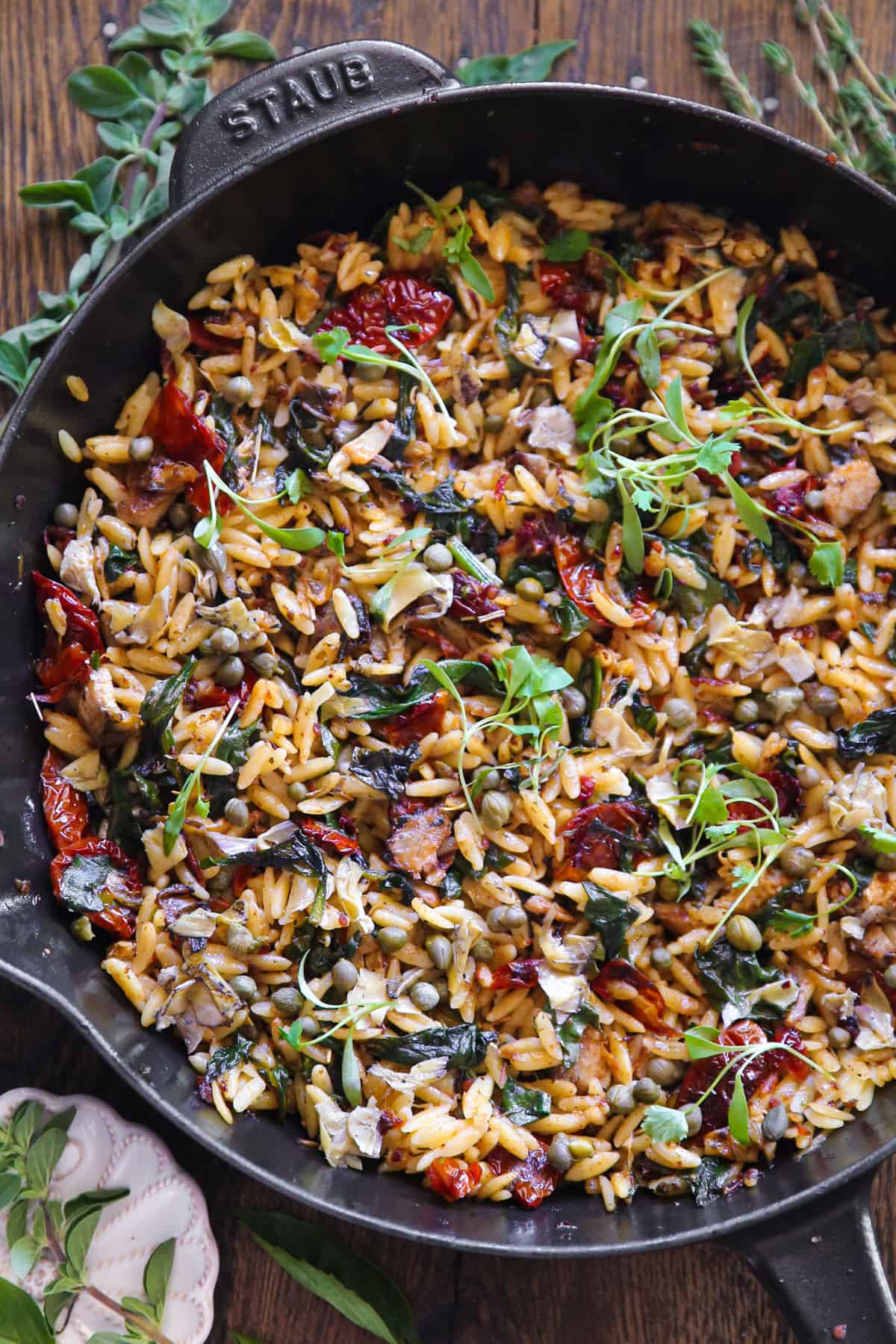 Sun-Dried Tomato and Spinach Orzo with Artichokes and Capers - in a cast iron skillet.