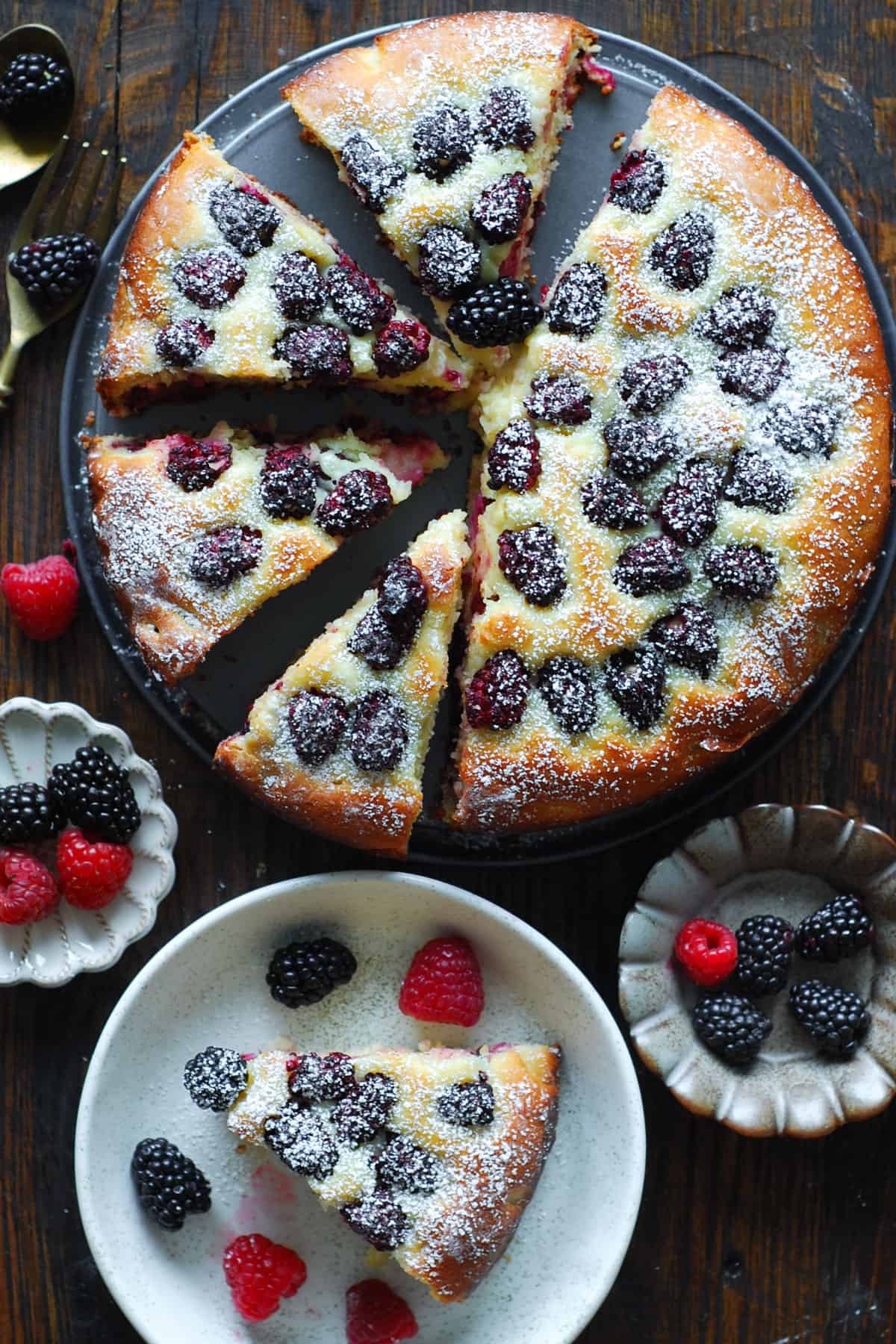 blackberry cake (sliced) on a platter with one cake slice on a plate.