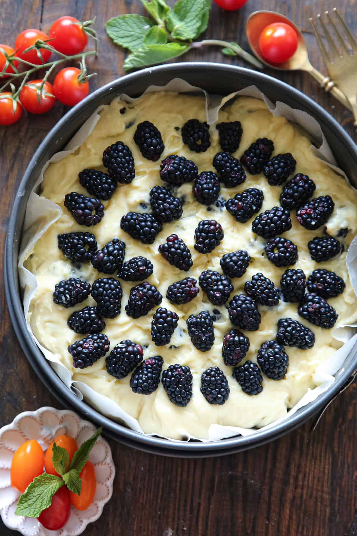 cake batter topped with blackberries in a springform pan.