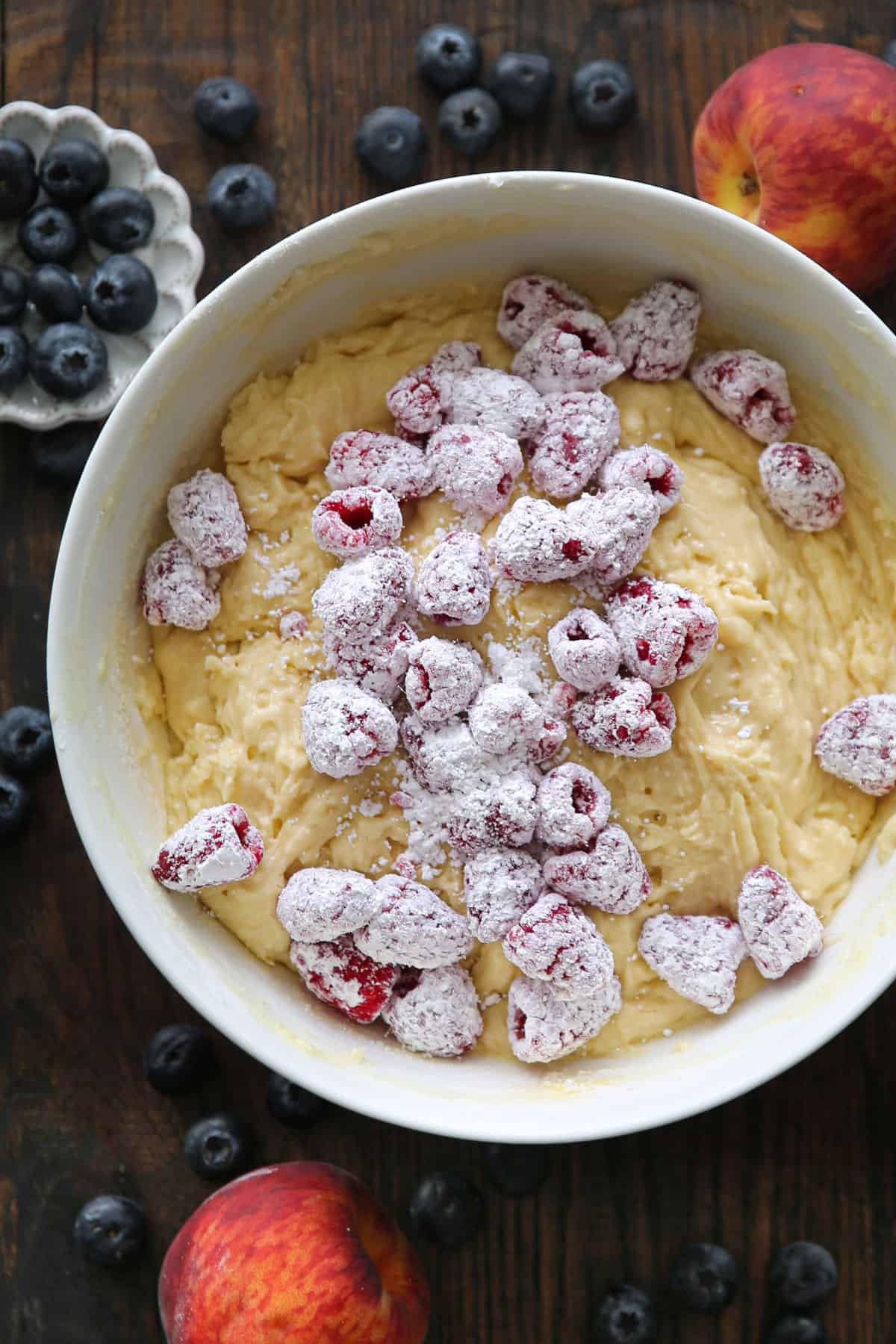 cake batter with fresh raspberries in a white bowl.